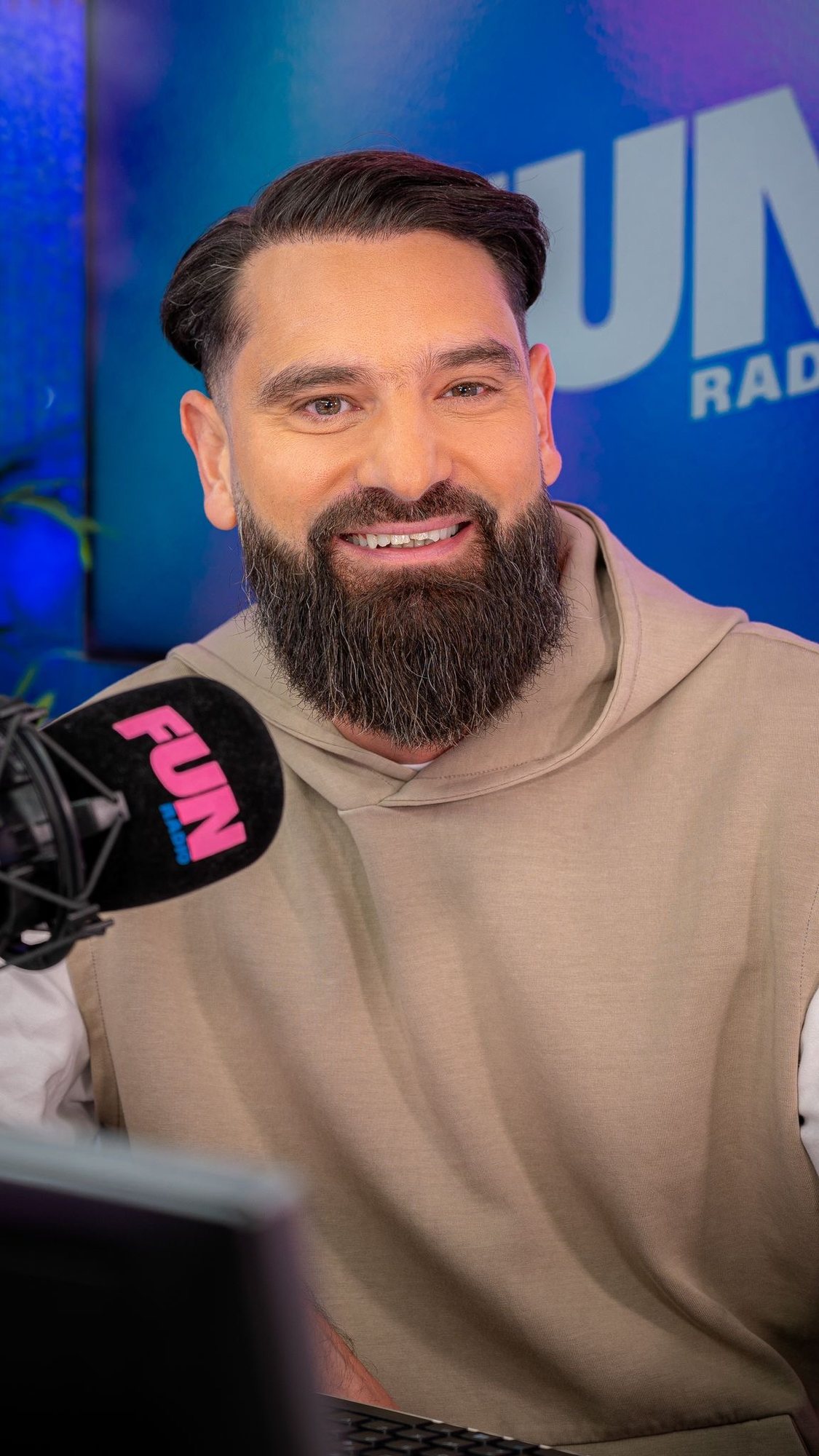 Alter Melego smiling at the Fun Radio microphone
