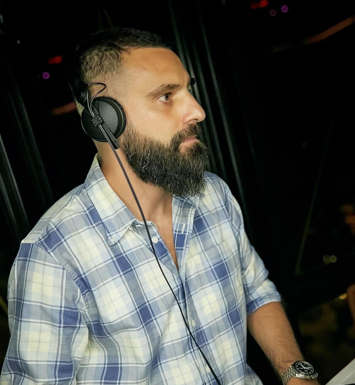 Alter Melego at the mixer, headphones on